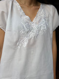 Camicia bianca con bordo ondulato e ricamo