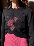 Maglione nero con fiori applicati